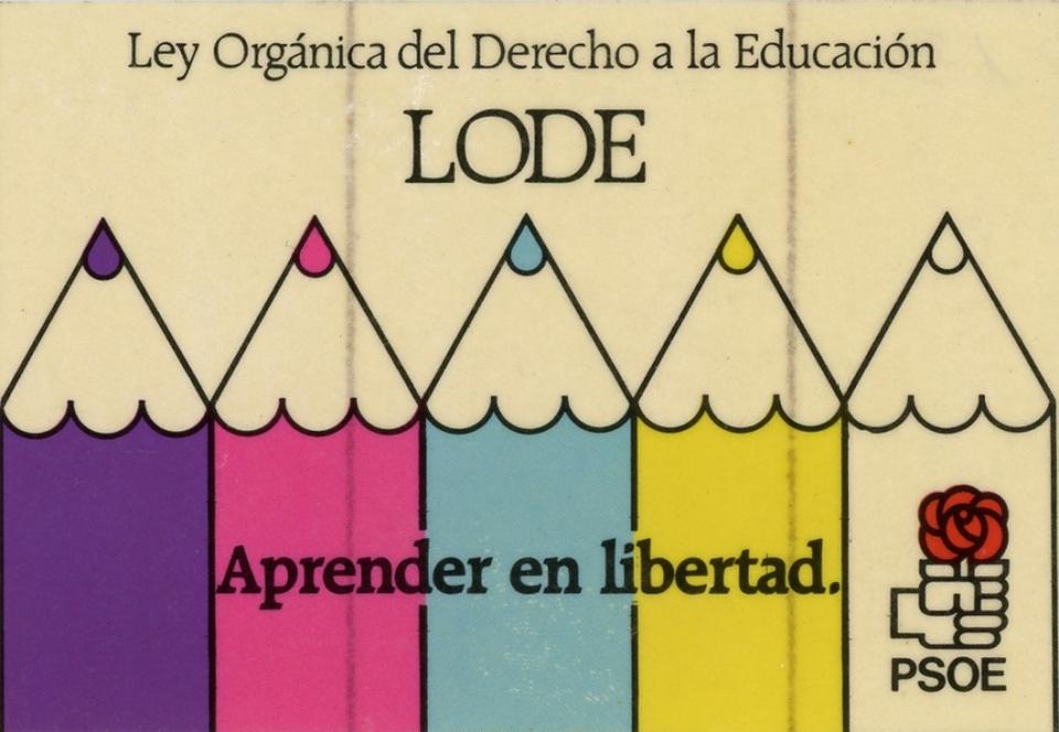 The sticker shows the tips of five color pencils coming up from the bottom up in the colors (left to right): purple, pink, blue, yellow and white. On the bottom right hand corner there is the logo for the Partido Socialista Obrero Español (PSOE), which is a sideways fist holding a red flower. The sticker is advocating for the right to education.